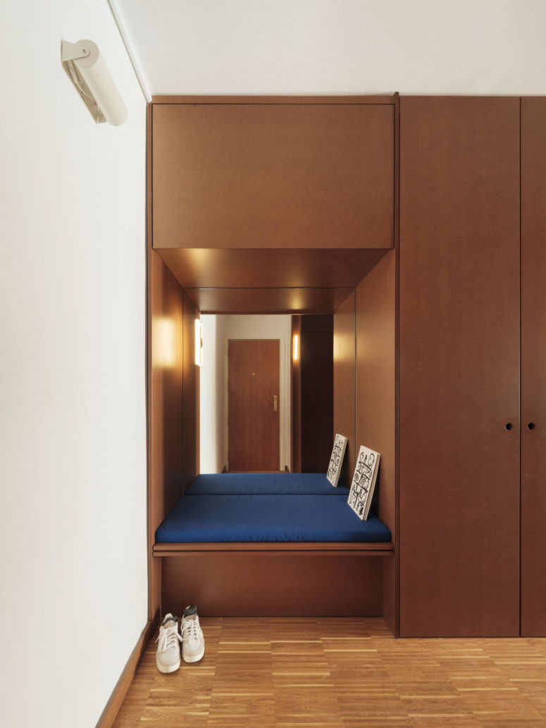 The entryway features a lot of storage space and a built-in seat with a mirror