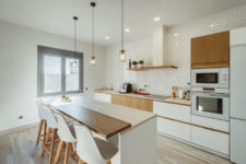 10 There’s another, cozy little kitchen done in white and natural light-colored wood, with subway tiles and pendant lamps