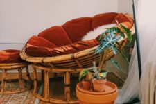 10 a rattan papasan chair with a rust velvet futon and a matching footrest plus some potted plants