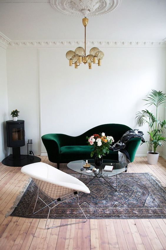 a vintage dark green velvet sofa and a medallion on the ceiling to add a chic look to the space
