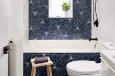 11 The bathroom is clad with printed navy tiles paired with white subway ones, there’s a window for light
