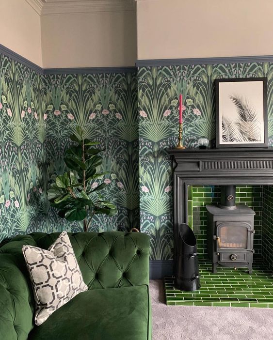 a moody living room with dark botanical wallpaper, green tiles, a matching sofa and potted plants feels outdoors
