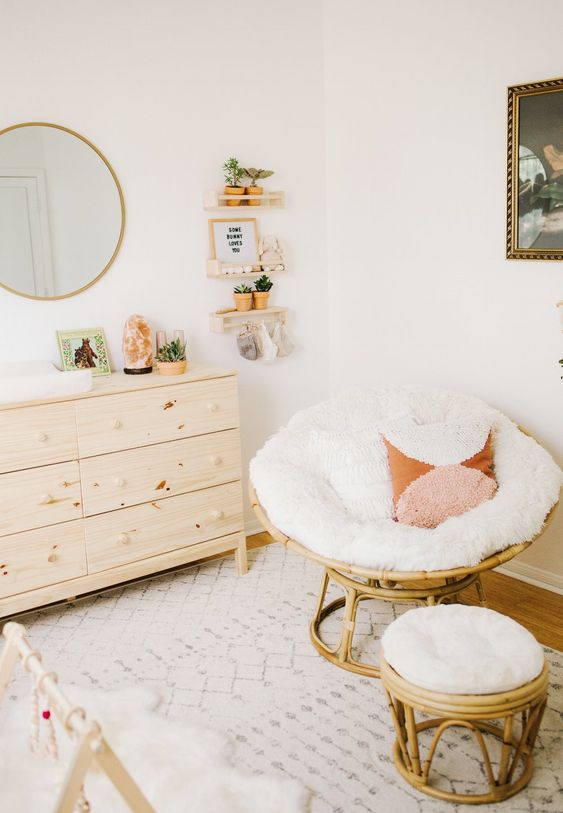 a neutral papasan chair with a white futon and fringe pillows plus a matching footrest for a neutral nursery