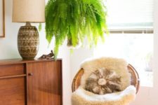 12 a woven papasan chair with a faux fur rug and a pillow paired with a faux leather ottoman for a boho space