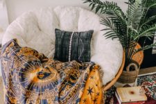 14 a boho reading nook with a rattan papasan chair with a white futon and a bright zodiac blanket plus a plant and colorful rugs