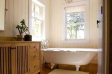 17 a farmhouse bathroom with a white vintage clawfoot tub that sets the tone in the space