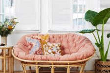 17 a rattan mamasan chair with a pink futon, floral pillows and blooms and potted plants for a boho space