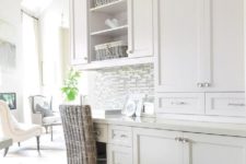 17 a white rustic kitchen with a built-in desk and a woven chair for working or finding out