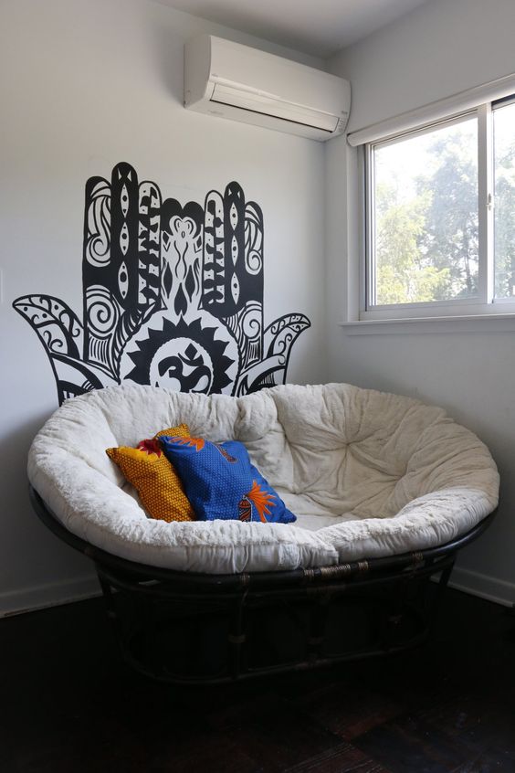 a cool papsan chair with cute pillows