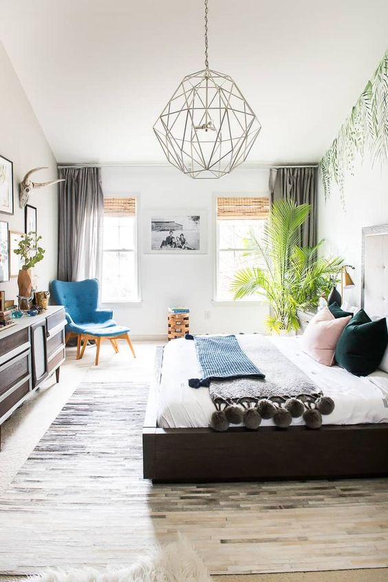 a boho bedroom with a statement tropical plant in the corner that catches an eye