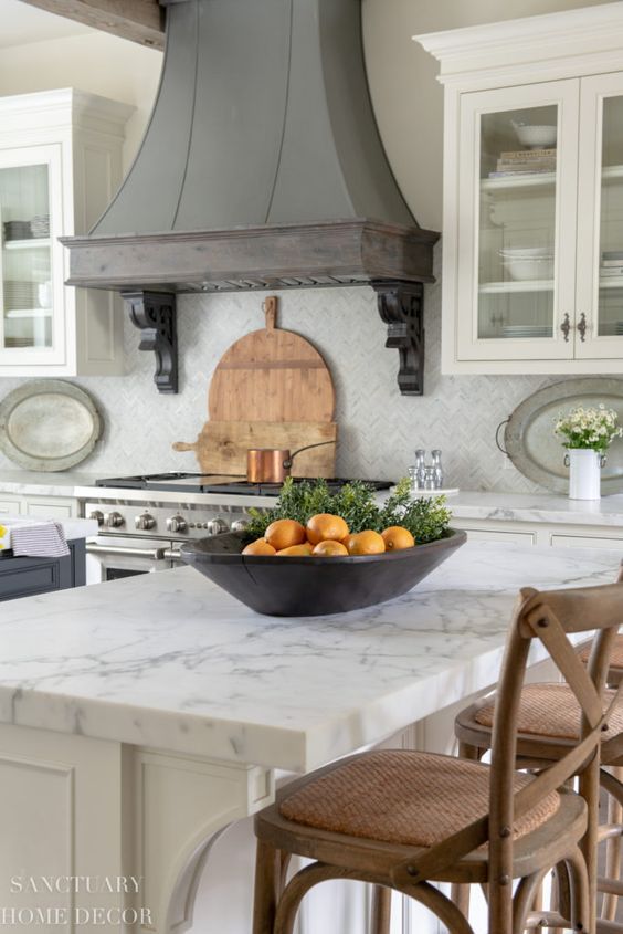 a neutral kitchen with white stone countertops and a vintage metal hood in greys to add chic and color