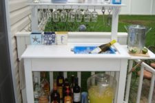 20 a stylish and simple outdoor bar station with glasses, bottles and even a wine cooler