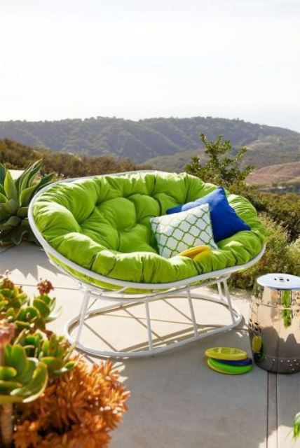 a white mamasan chair with a green futon and bright pillows is an amazing item for a modern outdoor space