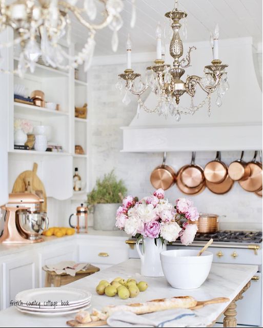 a stylish modern white kitchen with two vintage chandeliers that add chic and beauty to the space