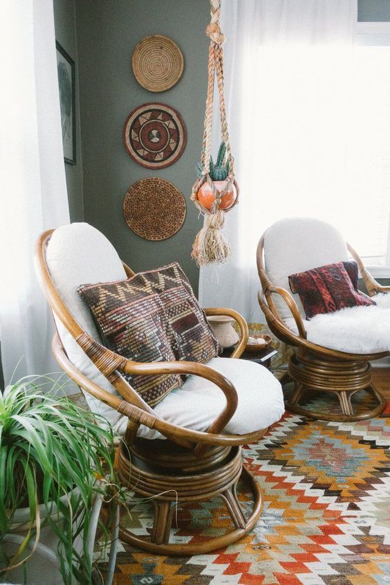 a duo of wooden papasan swivel rockers with white futons and boho and folksy pillows