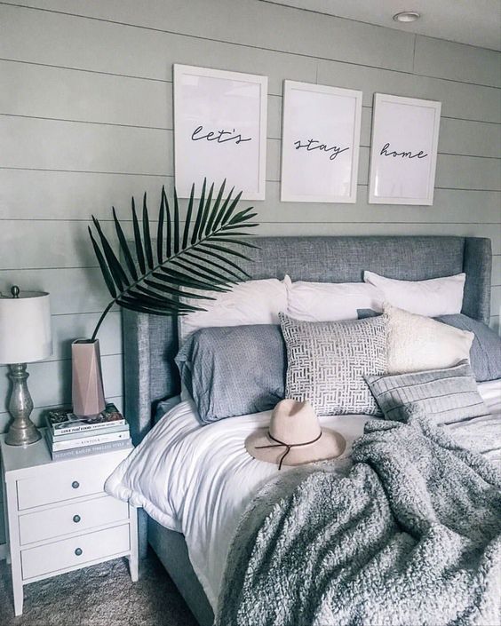 a boho bedroom in neutrals with an upholstered bed and some matching throws but of different fabric
