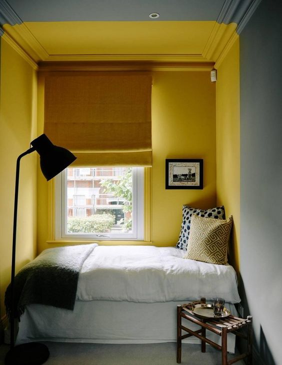 a small reading nook with bright yellow walls that define this nook in the grey space
