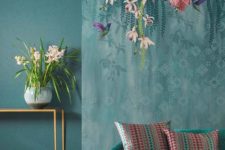 25 a moody space with catchy flora and fauna wallpaper that imitates hanging blooms over the furniture