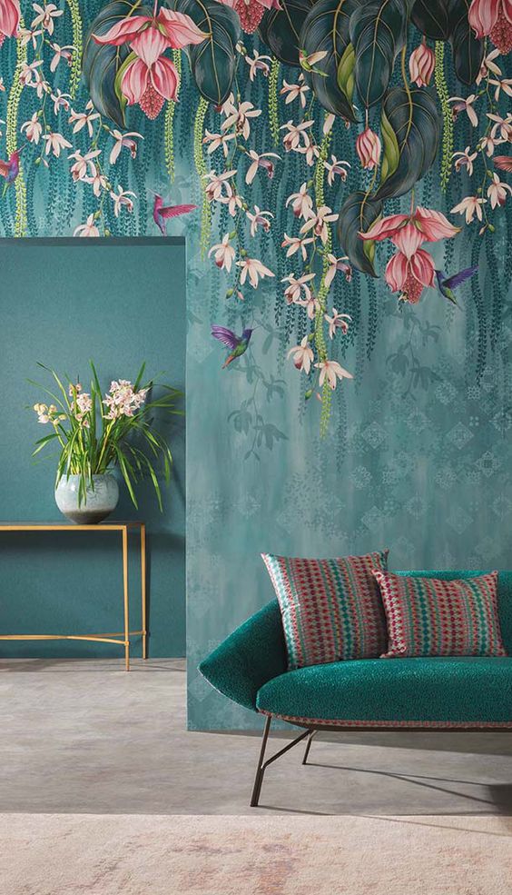 a moody space with catchy flora and fauna wallpaper that imitates hanging blooms over the furniture