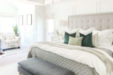25 a neutral bedroom with a grey statement bed, an arrangement of pillows