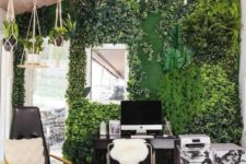 a biophilic home office with a greenery wall and potted plants hanging from above looks very fresh