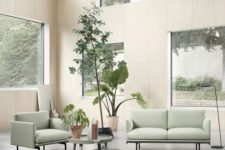 a biophilic living room with lots of windows to maximize the views and light and some potted plants inside