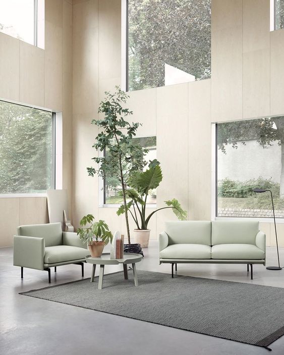 a biophilic living room with lots of windows to maximize the views and light and some potted plants inside