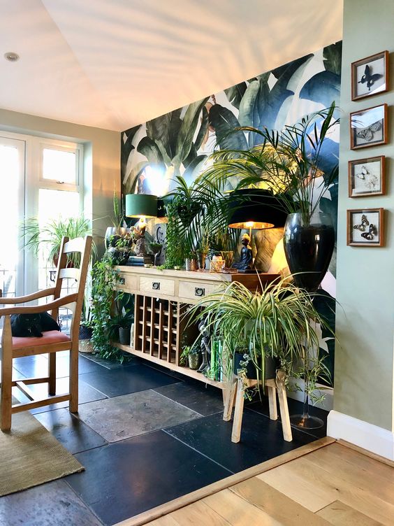 a biophilic space with potted greenery and plants, with a tropical print wall and wooden furniture
