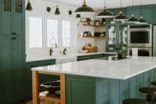 a bold green kitchen with shaker style cabinets, white stone countertops that echo with white walls, black pendant laps and sconces
