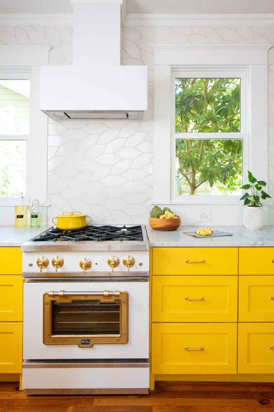a bright kitchen with sunny yellow cabinets, a catchy white tile backsplash and all white everything for a fresh feel