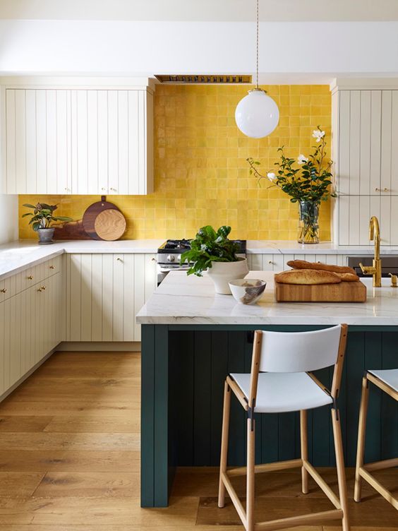 a bright kitchen with white plank cabinets, a yellow tile backsplash and teal kitchen island with stone countertops