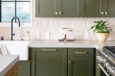 a catchy green kitchen with a white tile backsplash and gold touches plus black fixtures is super stylish