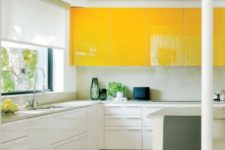 a contemporary kitchen with upper bright yellow cabinets, white ones and a white backsplash looks ultra bold