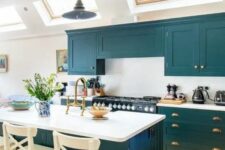 a lovely teal kitchen with a white backsplash and countertops, a matching kitchen island with white countertops and a backsplash