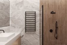 a minimalist bathroom clad with grey marble tiles, a wood vanity and wood look tiles in the shower space