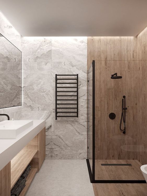 a minimalist bathroom clad with grey marble tiles, a wood vanity and wood look tiles in the shower space