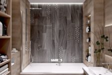 a minimalist bathroom done with wood look tiles and mosaic ones on the floor and bathtub wall for a pattern