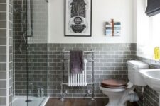 a modern bathroom with wood look tiles on the floor and grey subway tiles on the walls, white vintage appliances and a bold poster
