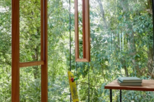 a perfect biophilic home office with glazed walls that allow natural light and a cool woodland view at the same time