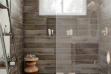 a pretty modern bathroom with wood tiles in the shower and neutral tiles on the floor, a window, a niche and a ladder shelving unit
