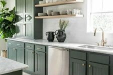 a stylish olive green farmhouse kitchen with fluted cabinets, white stone countertops, open shelves, brass and gold lamps