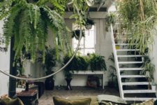 a super biophilic space with lots of greenery everywhere and natural fabrics for upholstery – this room looks like jungle