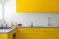 a super bright contemporary kitchen with yellow cabinets, a white subway tile backsplash and a wooden floor looks wow