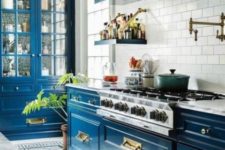 a super brigth blue kitchen with a white tile backsplash and lots of gold for pulling off art deco style