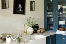 a teal kitchen refreshed with a white tile backsplash and countertop plus gold handles and fixtures