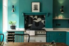 a teal kitchen with chic cabinets and matching walls for a sleek look, white stone countertops and a dining zone with vintage furniture