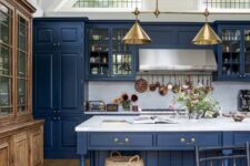 a vintage-inspired kitchen in classic blue, with a white marble backsplash and countertos plus gold lamps