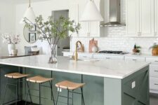 a white farmhouse kitchen with shaker style cabinets, an olive green kitchen island, white stone countertops and white pendant lamps