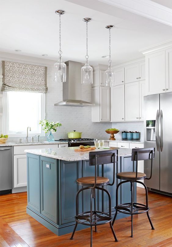 a white kitchen with a grey tile backsplash and a blue kitchen island plus white stone countertops is chic