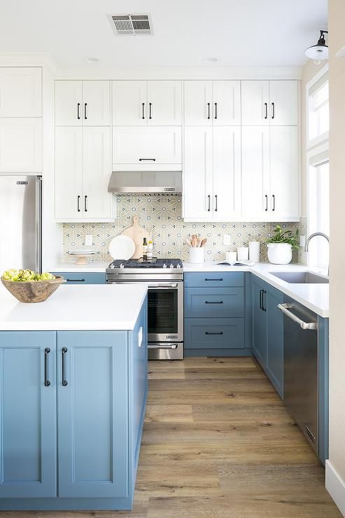 an elegant blue and white kitchen with a mosaic tile backsplash and white countertops, shaker style cabinets is all cool